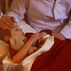 5-year-old Caleb lays in bed as his parents comfort him.